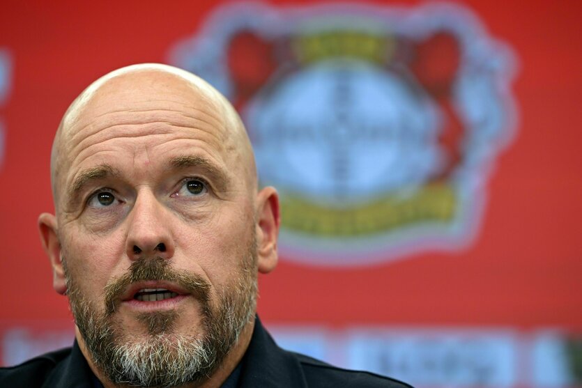 Porträtfoto von Erik ten Hag, im Hintergrund das Emblem von Bayer 04 Leverkusen