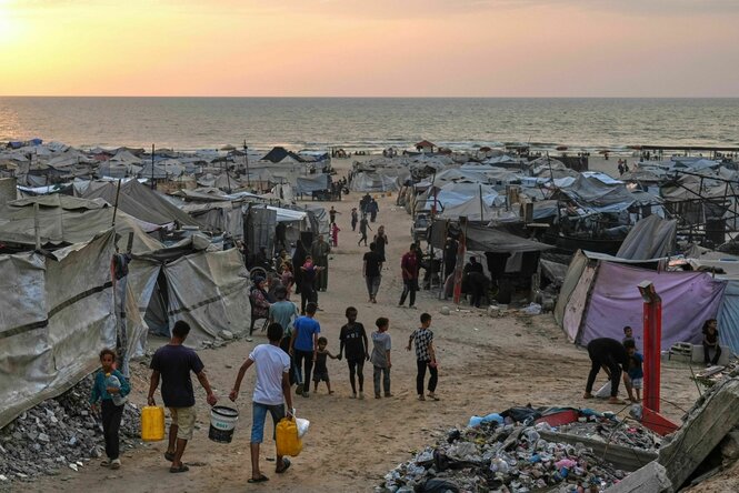 Vertriebene Palästinenser gehen durch ein behelfsmäßiges Lager am Strand von Gaza-Stadt
