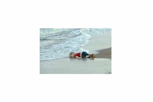 Ein Junge liegt leblos an einem Strand