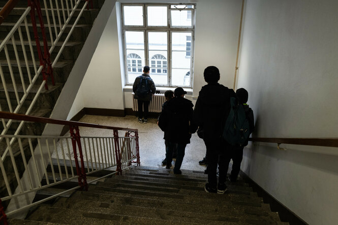 Schueler im Treppenhaus. Blick auf den Schulcampus Ruetli