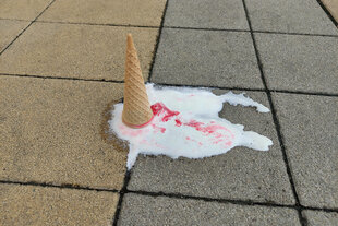 Ein Eis liegt geschmolzen auf dem Boden