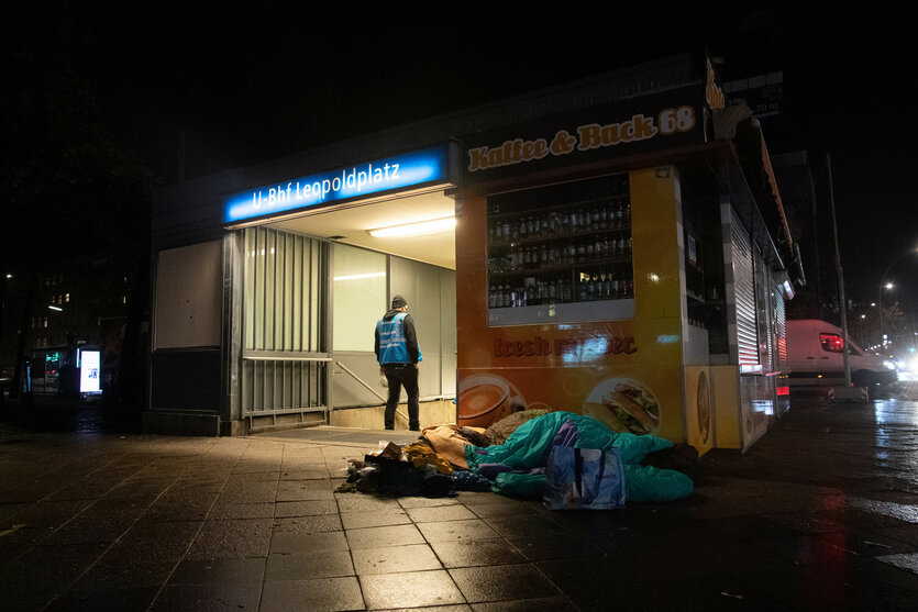 Ein Mitarbeiter des Kältebus der Berliner Stadtmission steht am Bahnhof Leopoldplatz neben dem Lager eines Obdachlosen.