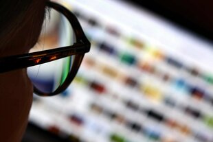Blick durch Brille auf unscharfen Monitor