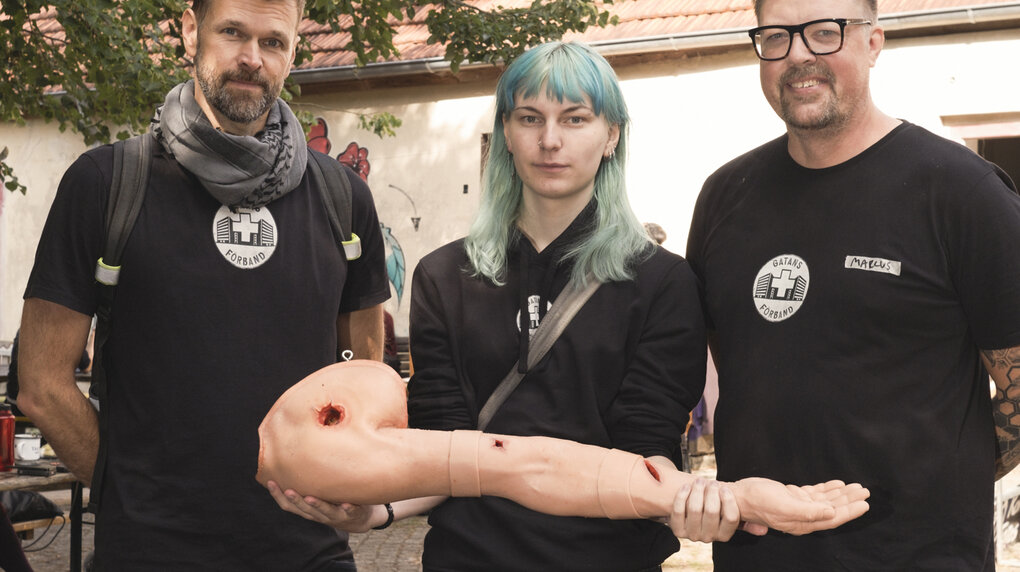Mehrer Personen zeigen einen Kunstarm an dem Erste Hilfe geübt werden kann.