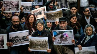 Protestierende halten Fotos hoch, die an das Massaker in Dersim erinnern sollen