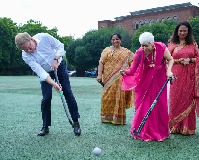 Bundesaußenminister Johann Wadephul (CDU) besucht in der «Modern School Vasant Vihar» das Hockey-Training von Schülern und schiesst einen Ball, Leherinnen schauen zu