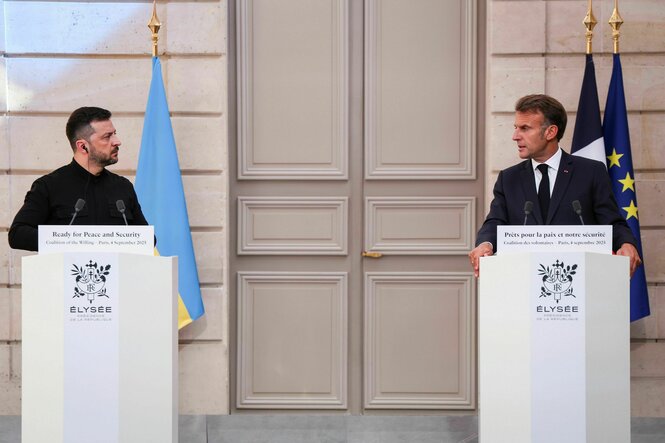 Frankreichs Präsident Emmanuel Macron (r.) und der ukrainische Präsident Wolodymyr Selenskyj (l.) stehen an Rednerpulten und schauen sich an