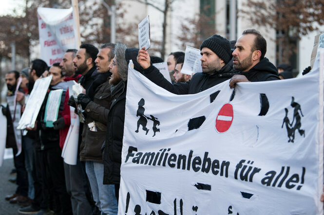 Eine Gruppe von Männern hält auf einer Kundgebung Schilder und ein großes Banner mit der Aufschrift "Familienleben für alle!"
