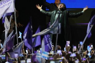 Javier Milei die Arme ausgebreitet, den Kopf gen Himmel gereckt, vor ihm eine euphorische Menge