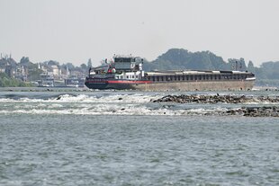 Ein Binnenschiff fährt über den Rhein. Bei anhaltender Trockenheit und ausbleibenden Niederschlägen drohen der Schifffahrt Einschränkungen