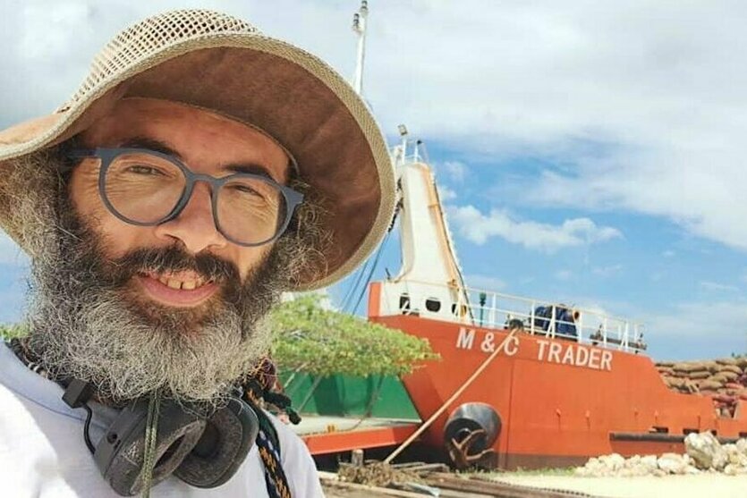 Gianluca Grimalda vor einem Schiff.