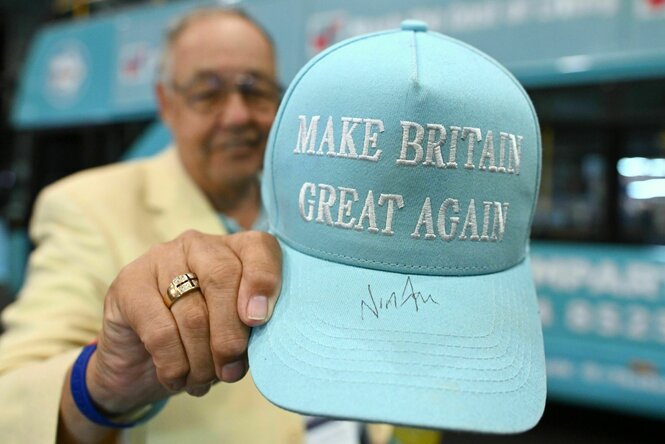 Ein Mann hält ein Basecap in die Kamera. Darauf steht:" Make Britain great again."