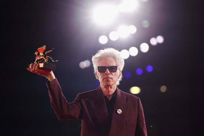 Jim Jarmusch hält den Goldenen Löwen in die Kamera