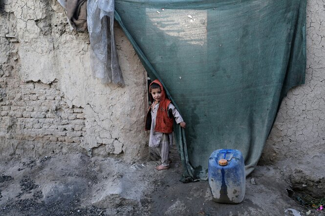 Kleiner Junge in Afghanistan schaut aus bescheidener Behausung in die Kamera
