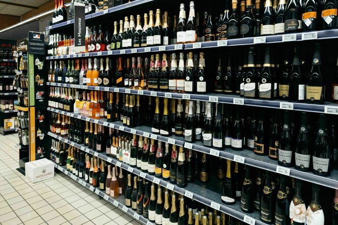 Ein Regal im Supermarkt mit alkoholischen Getränken wie Sekt und Champagner