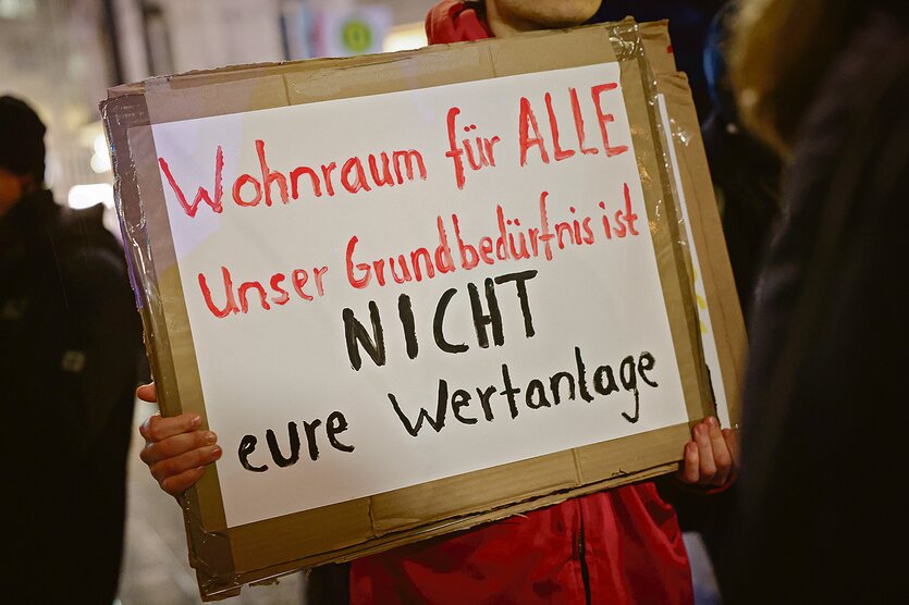 Ein Pappschild mit schwarzer und roter Schrift