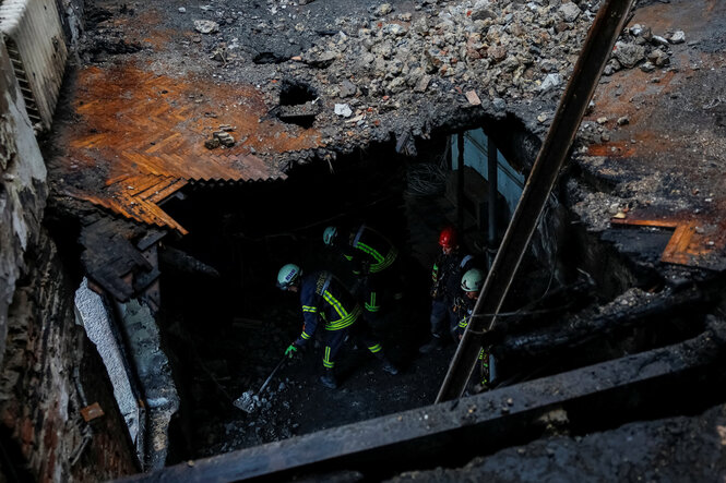 Feuerwehrmänner in einem zerstörten Regierungsgebäude in Kyiv nach einem russischen Angriff