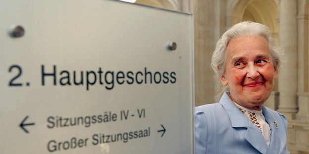Ursula Haverbeck 2009 neben einem Wegweiser im Bundesverwaltungsgericht in Leipzig