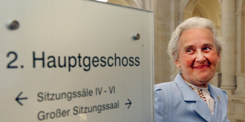 Ursula Haverbeck 2009 neben einem Wegweiser im Bundesverwaltungsgericht in Leipzig