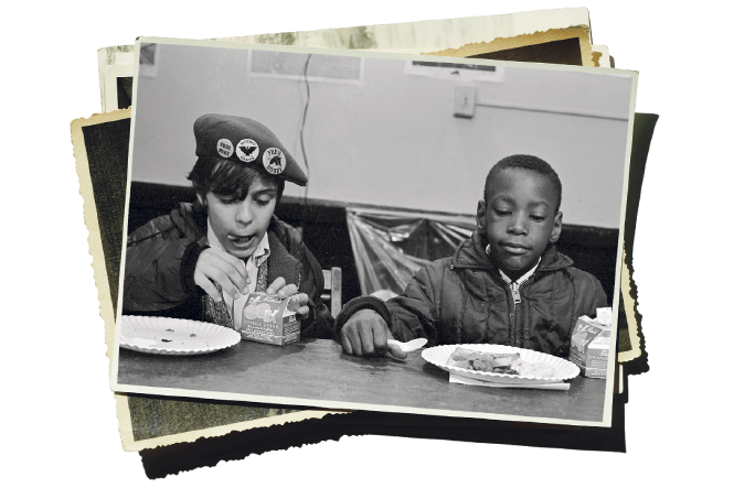 Ein Fotostapel mit historischen Bildern, ein Bild zeigt zwei Kinder beim Essen.