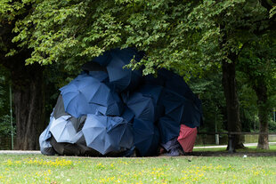 Eine Konstruktion aus Regenschirmen dient Obdachlosen als Unterkunft in einem Park