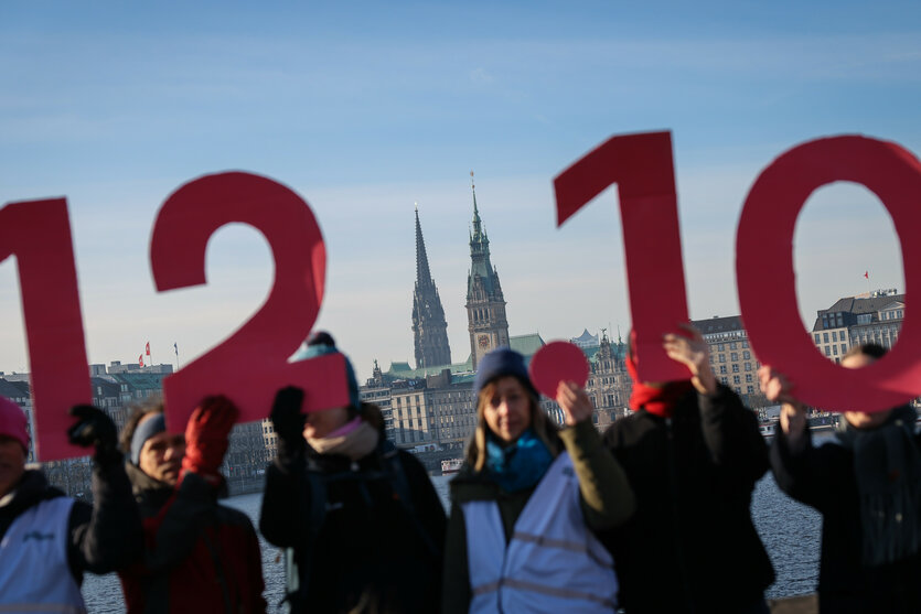Aktivist:innen halten Schilder mit der Aufschrift "12.10." hoch