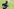 Leicht verwackeltes, seitliches Foto einer rennenden Person mit rot-weißem Helm mit der Aufschrift MSA. In der rechten Hand hält sie einen länglichen Staffelstab. Im Hintergrund ist Rasen.