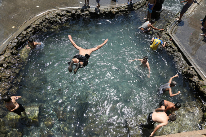 Junge Männer baden - einer springt ins kühle Nass