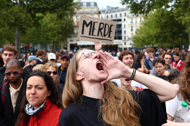 Eine Person schreit bei einer Demonstration.