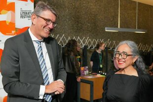 Wolfgang Weimer und steht neben der Schriftstellerin Cristina Rivera Garza, die beide freundlich lächeln
