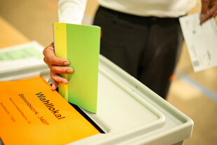 Ein Mann wirft seine Stimmzettel in eine Wahlurne