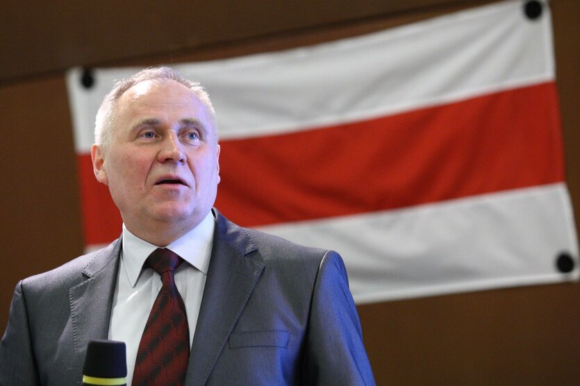 Nikola Statkevich spricht vor einer belarussischen Flagge