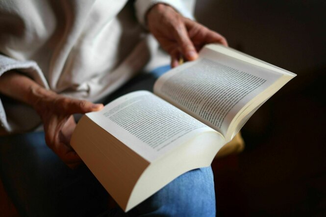Ein aufgeschlagenes Buch in den Händen einer Frau