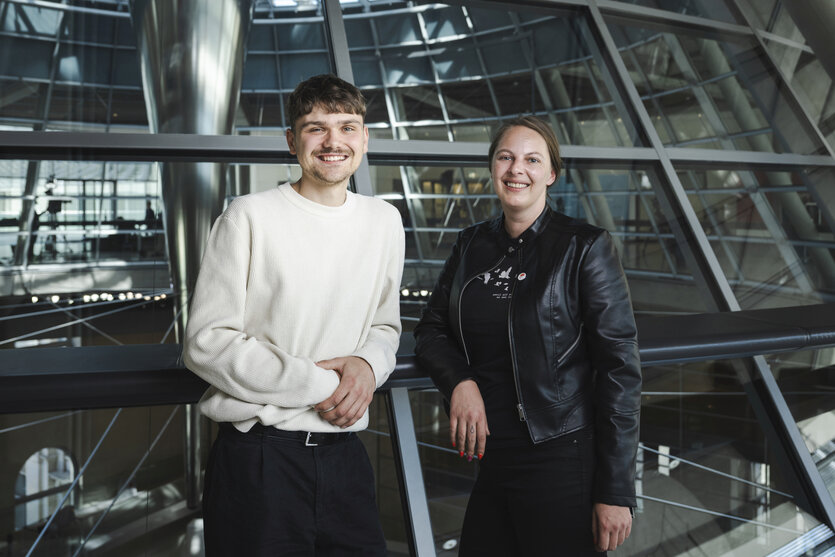 ein junger Mann und eine junge Frau lächeln in die Kamera