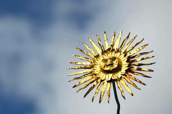 Eine dekorative Metall-Sonne ist auf einem Hausdach