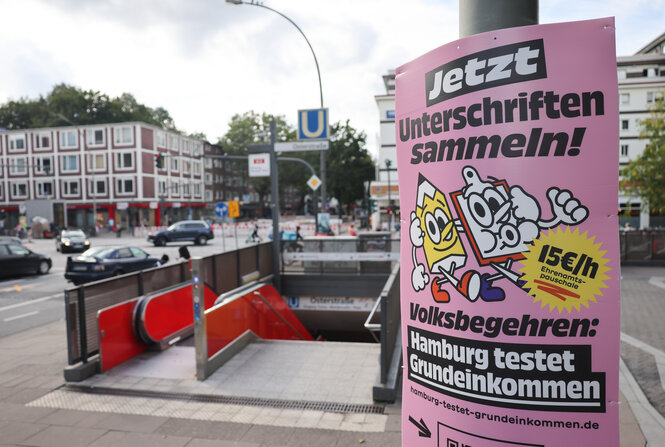 Plakat der Initiative Hamburg testet Grundeinkommen am Eingang zum U-Bahnhof Osterstraße