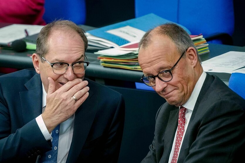 Merz abschätzig grinnend, und Dobrindt,hinter vorgehaltener Hand lästernd