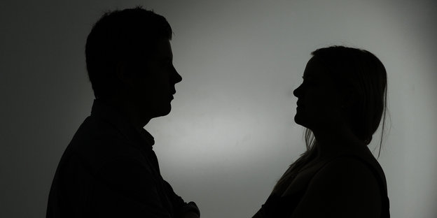 Silhouetten von Mann (links) und Frau (rechts), die sich gegenüber stehen.