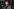 Ben Shapiro steht vor einer Werbewand und posiert