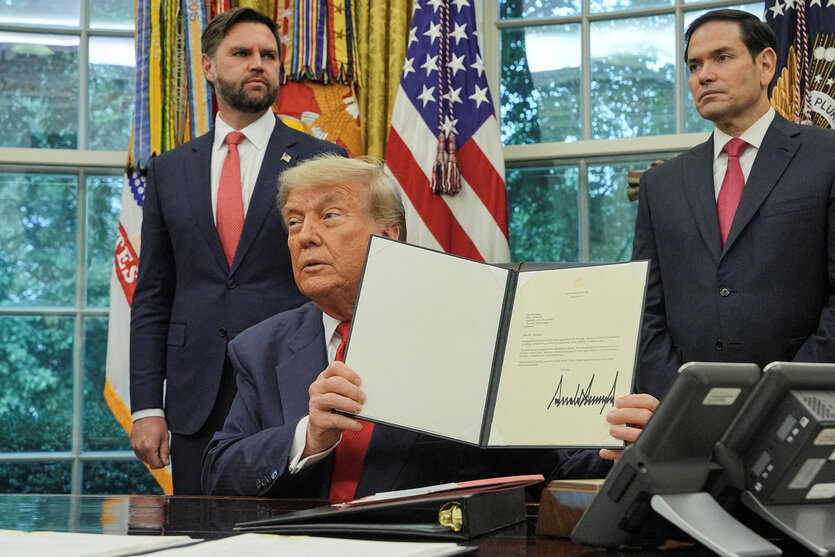 Donald Trump hält einen Brief hoch. Marco Rubio und JD Vance stehen hinter ihm