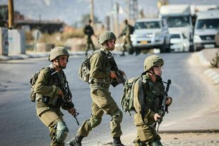 bewaffnete Soldaten laufen an einer Straße