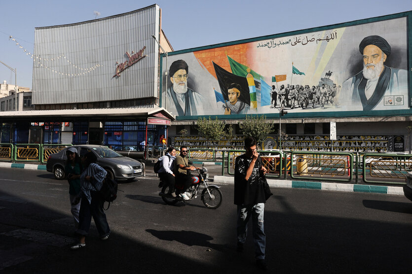 Straßenszene in Teheran - Ein Bild von Ayatollah Ali Khomenei an einem Geäude