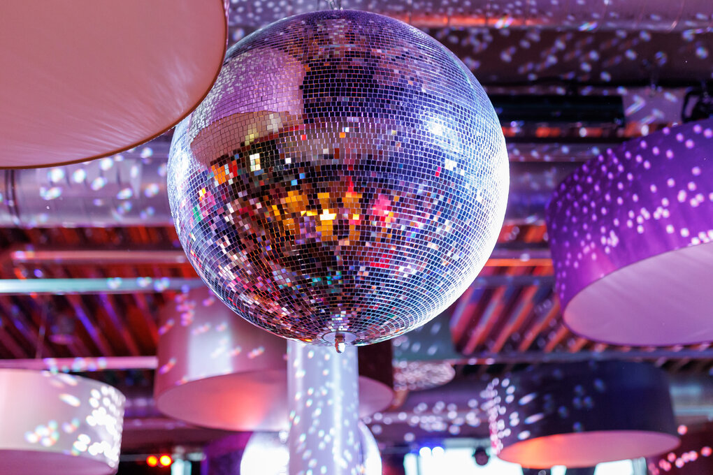 Eine Disco-Kugel hängt in einem Club über der Tanzfläche