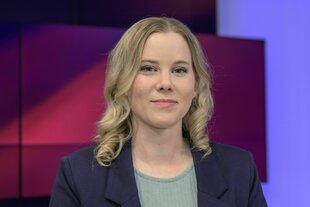 Porträt von Julia Ruhs, sie hat halblange blondgelockte Haare und trägt T-Shirt und Jacket