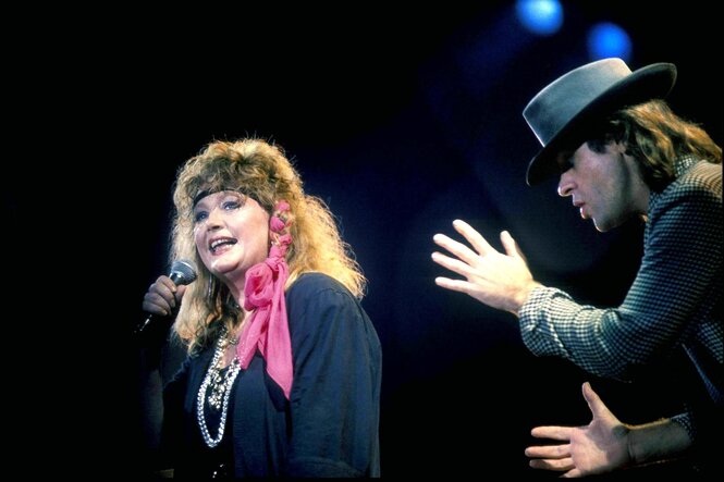 Alla Pugatschowa mit blonden Locken steht gemeinsam mit Udo Lindenberg auf der Bühne und singt in ein Mikrofon