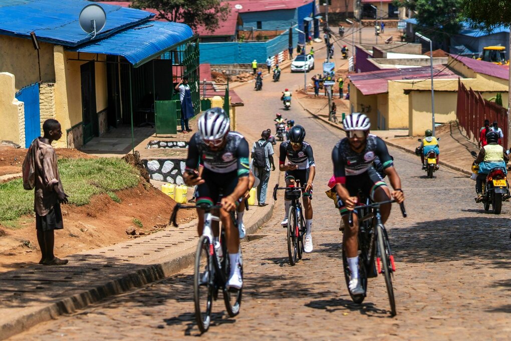 Drei Rennradfahrer, die eine Straße in Kigali bergauf fahren