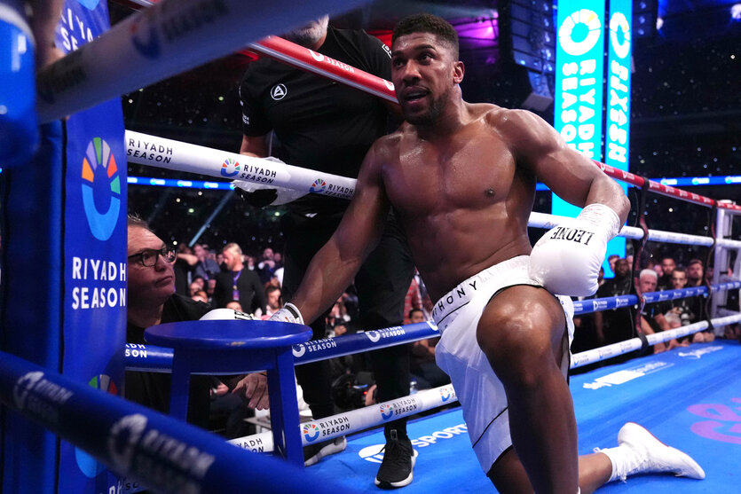 Anthony Joshua kniet in der Ecke des Boxrings vor einem blauen Hocker