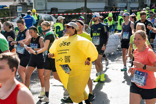 Mann läuft Marathon in einem aufblasbaren gelben Kunststoffanzug