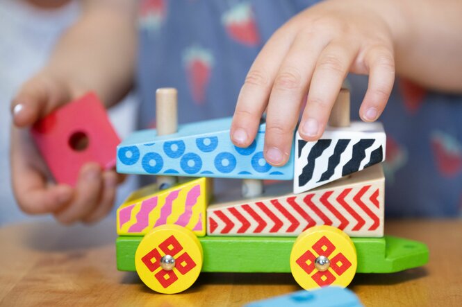 Kind mit Holzzspielzeug