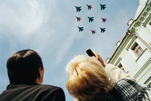 Zwei Personen schauen hoch zu Kampfjets